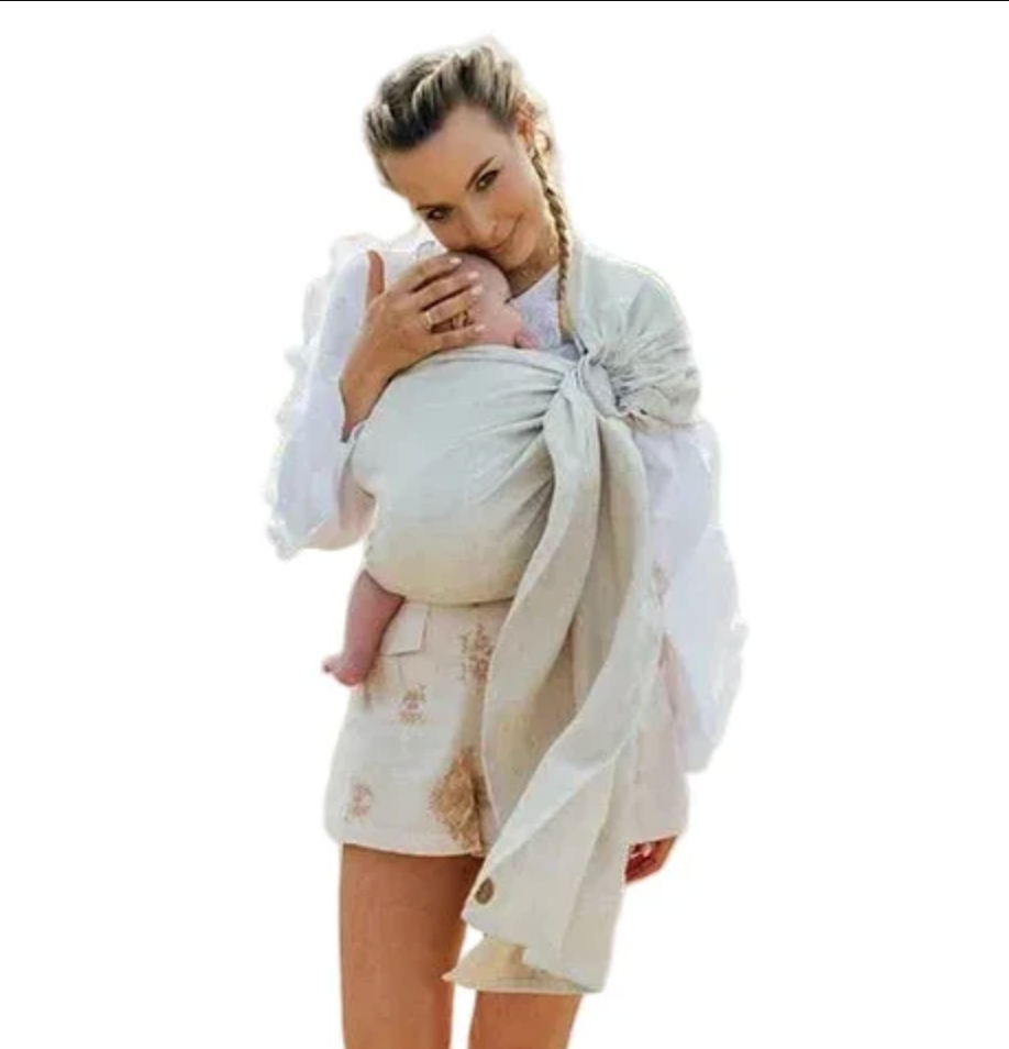 Woman walking with a baby in a ring sling.