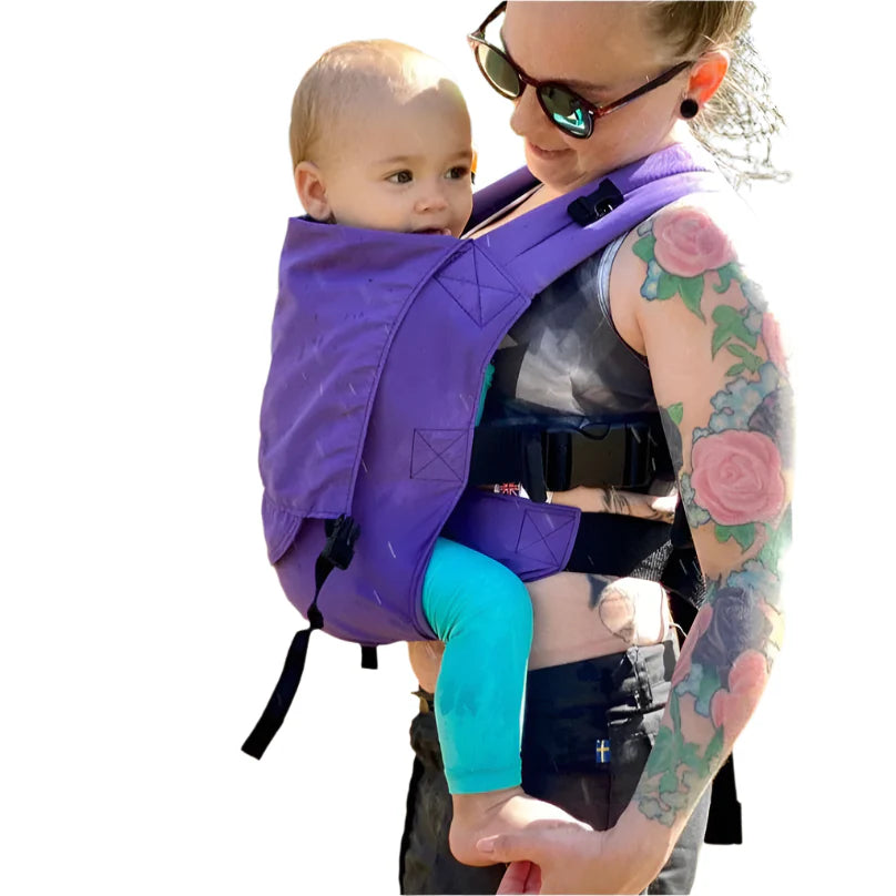 Parent wearing the Integra Solar baby carrier, designed with sun-protective fabric for hot weather babywearing.