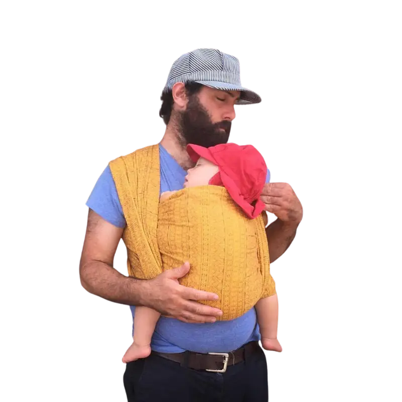 Image of a man. wearing his baby in a comfortable and secure woven wrap. The man is confidently supporting the baby against his chest, creating a heartwarming moment of connection.