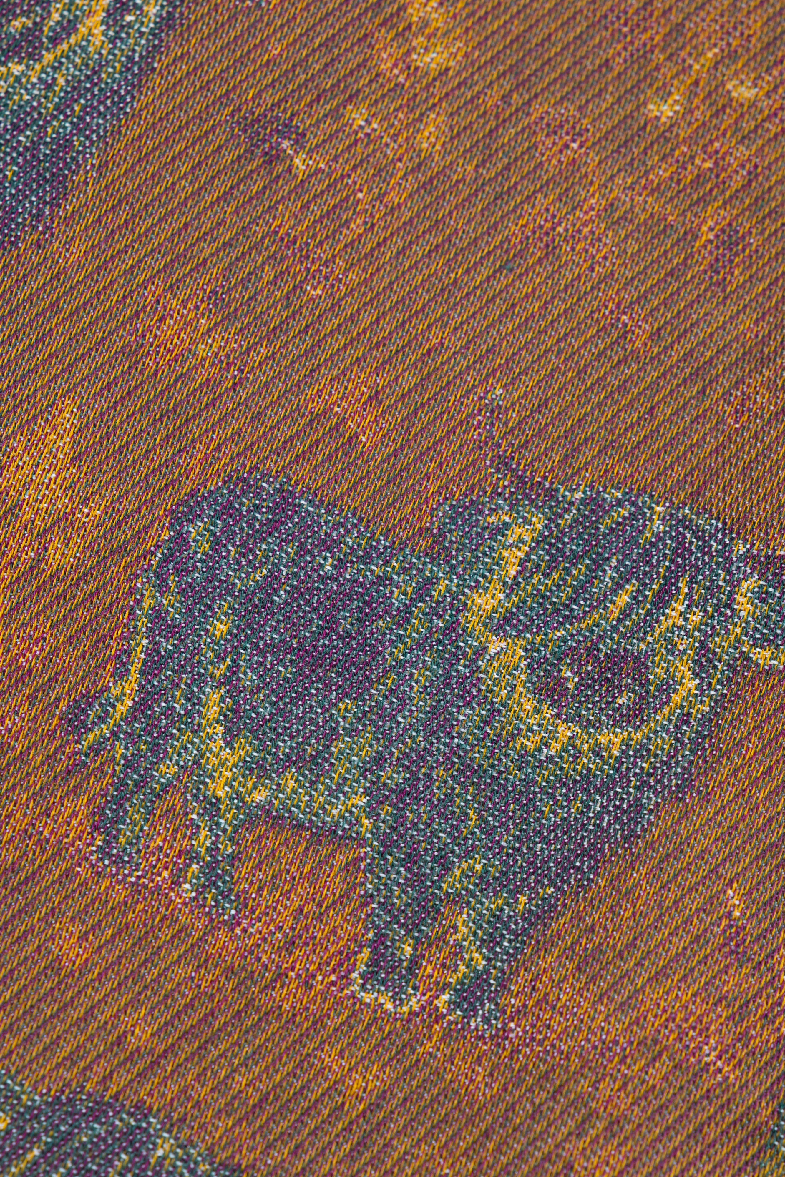 A close-up of a woven fabric pattern featuring a dark bull silhouette over a warm brown and orange textured background.