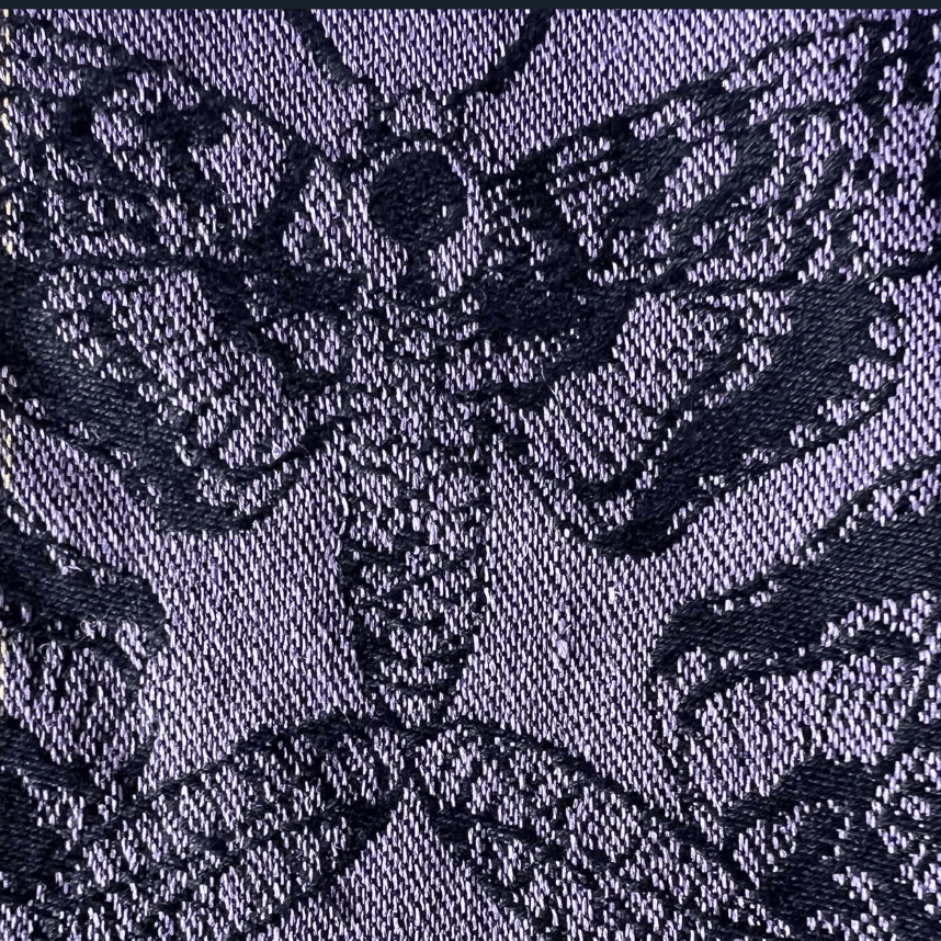 Close-up of a textured fabric with a floral pattern in black on a dark blue background