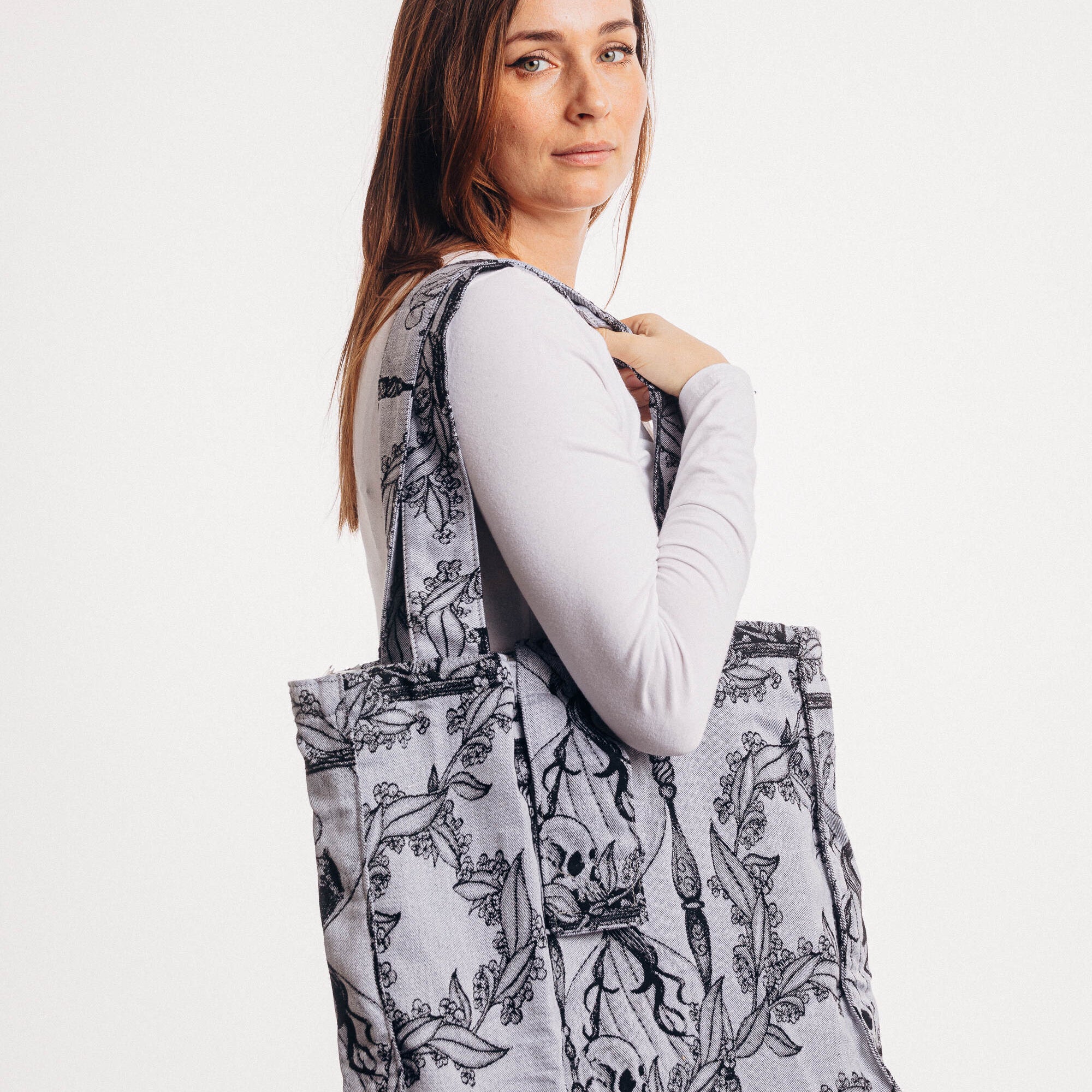 Woman carrying a patterned tote bag on a white background