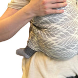 Woman holding a baby in a sling made of cashemre
